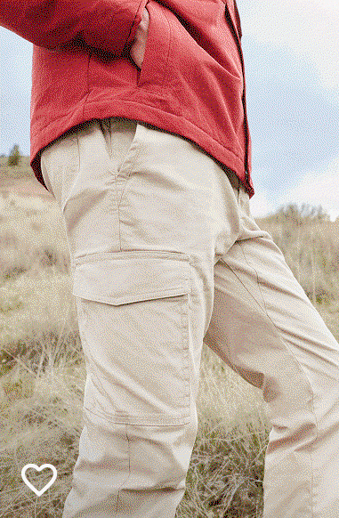 A man wearing a tan pair of pants and a red jacket.