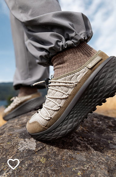 Close-up of a hiker's gray pair of shoes on a rock.