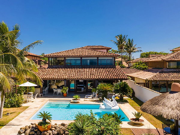 Sun-drenched home with palm trees, a sparkling pool, and inviting outdoor living spaces.