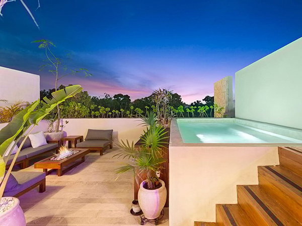 Rooftop terrace with plunge pool, lounge seating, and tropical views at dusk.