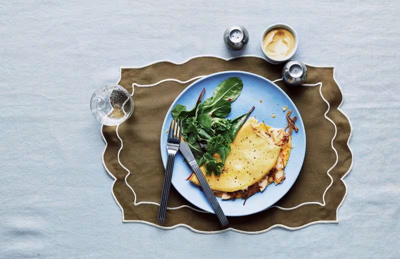 An omelette filled with caramelized onions, sliced Fuji apples, and fontina cheese and served with greens and Dijon mustard.