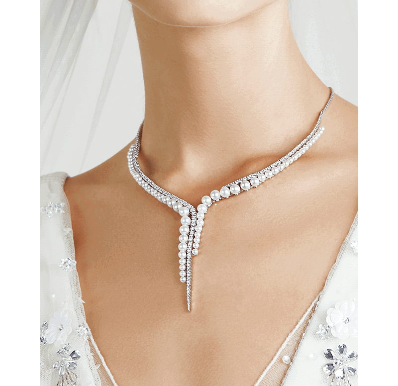 Close-up of a bride wearing a diamond and pearl necklace.