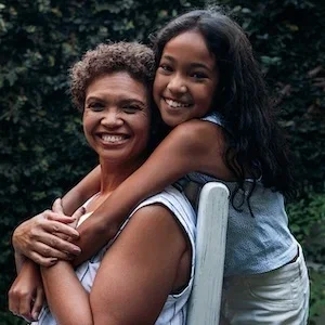 New Blog - Grandparents' Day. picture of girl and grandmother posing happily in garden