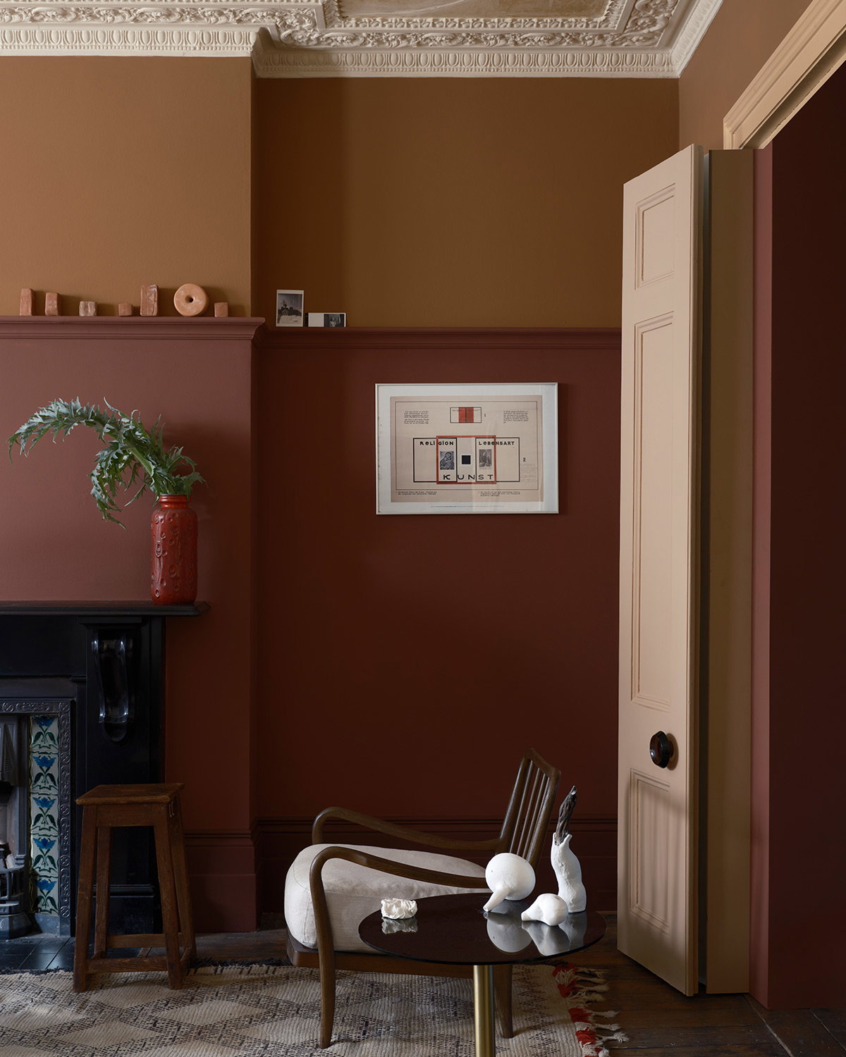 Living room featuring walls painted in Etruscan Red and Marmelo, showcasing rich red tones paired with warm neutral accents.