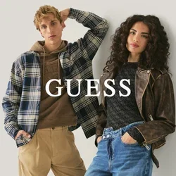 Twee jongvolwassenen leunen tegen een muur, gekleed in casual herfstkleding: een geruit jack, een hoodie, khaki broeken en een leren jas met spijkerbroek.