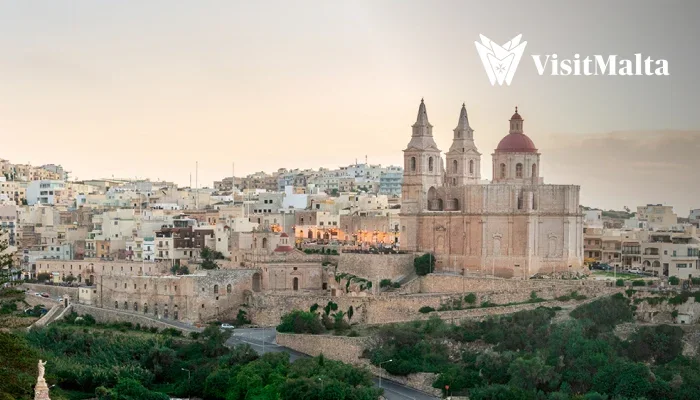 Historic Malta cityscape at sunset with the VisitMalta logo