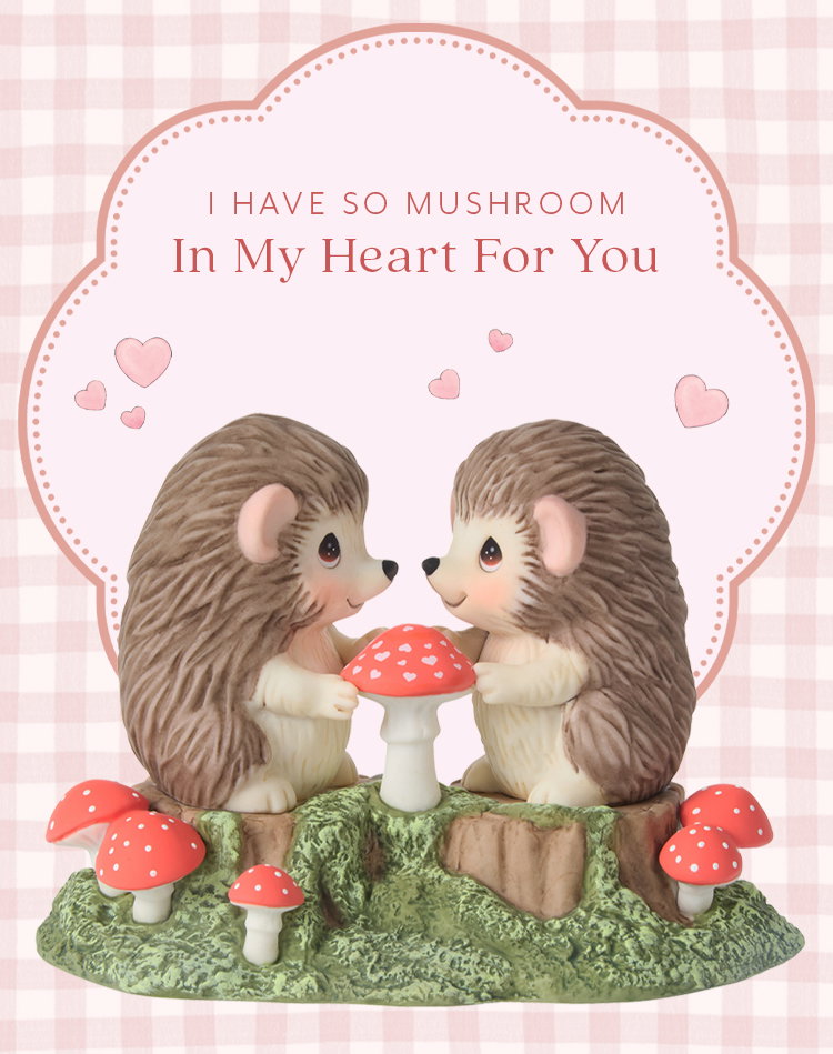 Precious Moments hedgehogs share a sweet moment over a heart-dotted mushroom.