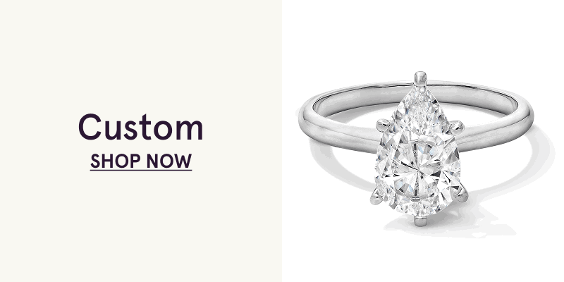 White metal band with large pear-shaped diamond center stone. Custom. Click here to shop now