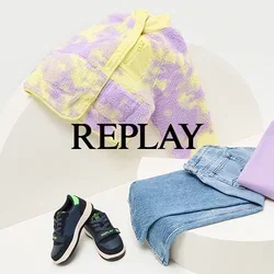Paarse en gele donzige jas, lavendelkleurig sweatshirt, blauwe jeans en marineblauwe sneakers met groene accenten, opgesteld op een gebogen witte display.