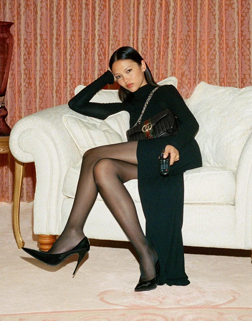 The classic black dress goes high impact with a back-baring panel, to-the-hip split and floor-skimming silhouette
