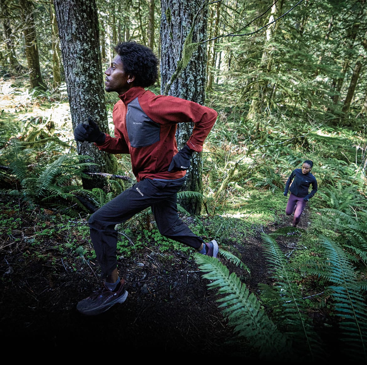 Man and woman running a trail in the woods