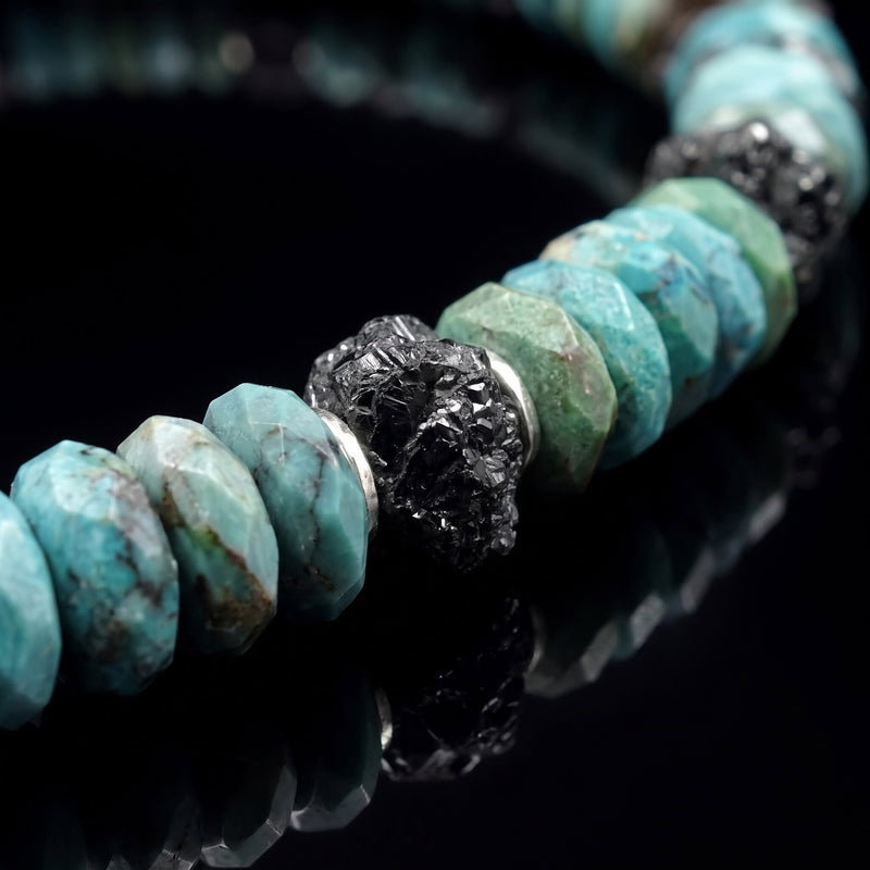 Close-up of raw black diamonds paired with turquoise.