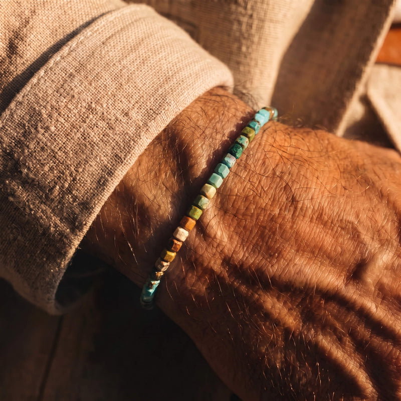 Turquoise IX with small 3mm cube-shaped beads, worn on a wrist.