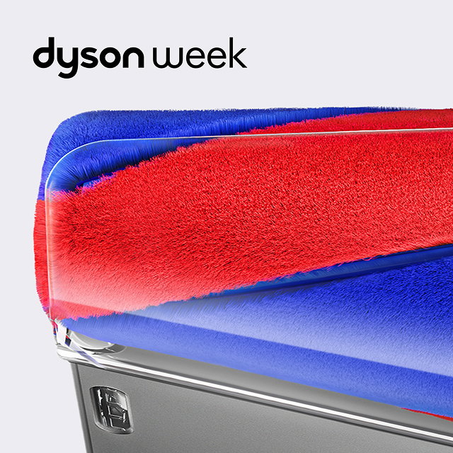 Close-up corner view of the red and blue conical brush bar of a Dyson Fluffycones cleaner head.