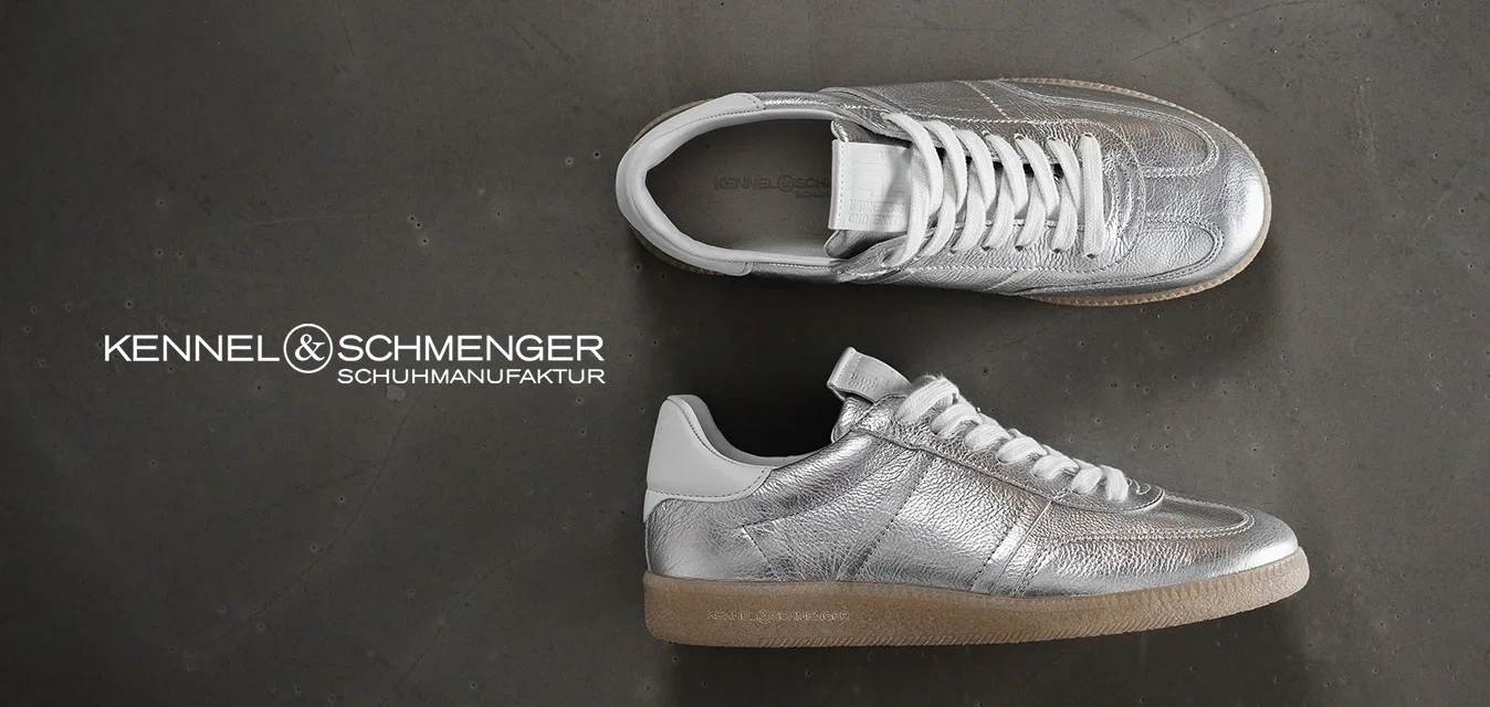 Metaalachtige zilveren sneakers met een gestructureerde bovenkant, witte veters en een tan rubberen zool, voorzien van minimalistische designelementen en stikseldetails.