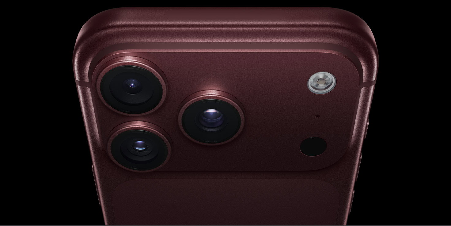 iPhone 18 Pro Max, burgundy color (dark red), back exterior, Pro Fusion camera system at top, 3 lenses, variable aperture blades partially closed, flash, microphone and LiDAR Scanner, top exterior, cellular antenna, flat sides, rounded edges