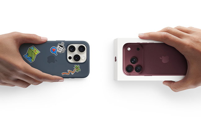 Hands exchanging trade-in. Older iPhone in a case with stickers for a new Burgundy iPhone 18 Pro in the box