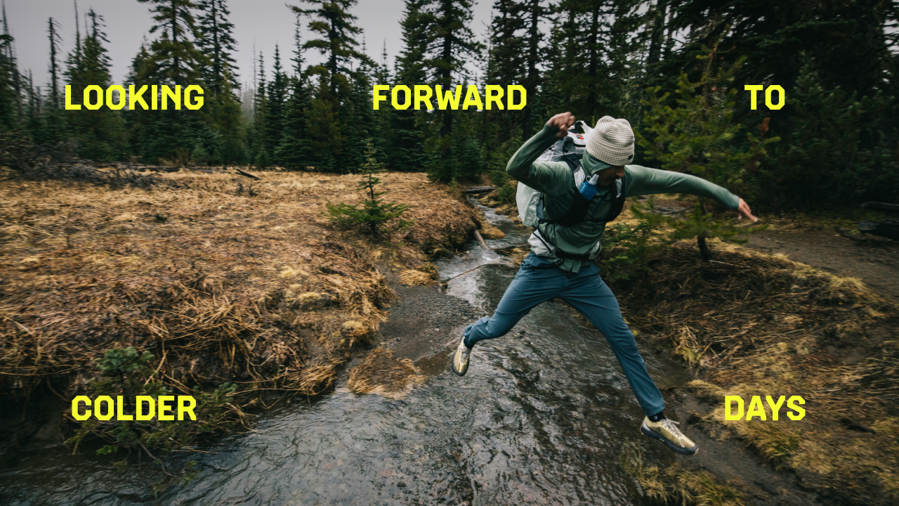 Looking forward to colder days. A hiker jumping over a creek.