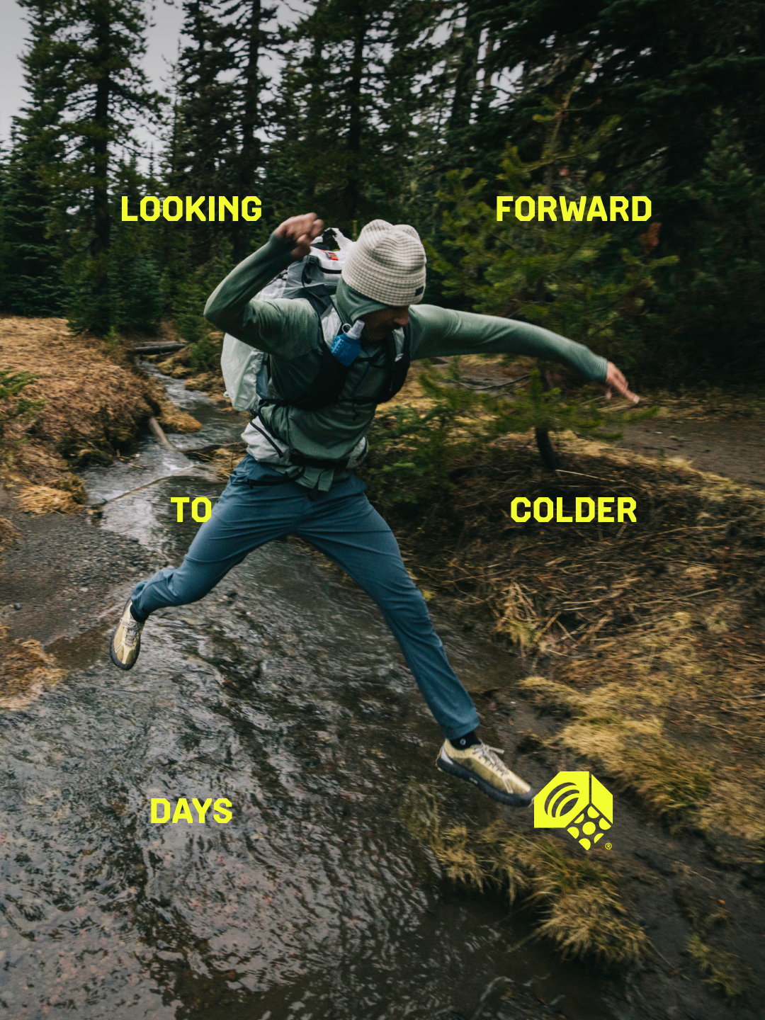 Looking forward to colder days. A hiker jumping over a creek.
