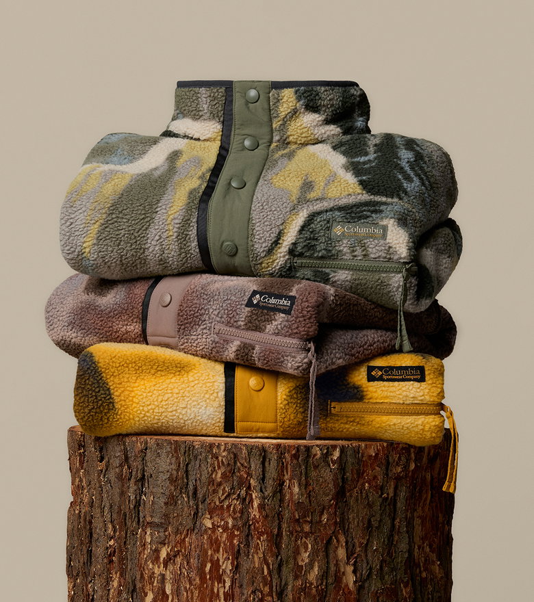 A stack of Helvetia fleece jackets sitting on a stump. 