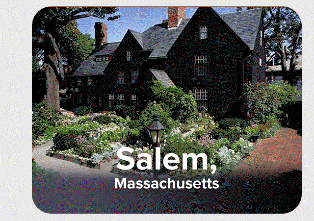 Historic Salem home with a rustic wood exterior, fronted by a garden of flowers and shrubbery.