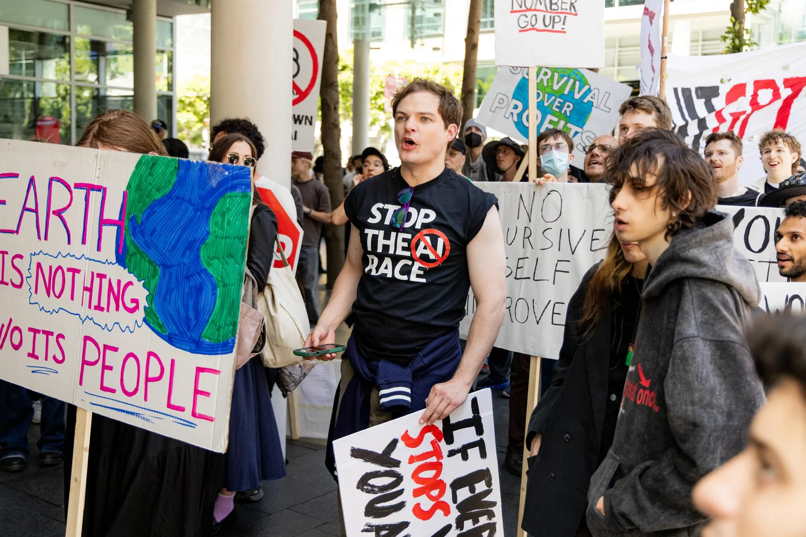 A group of young people stand with signs protesting AI.