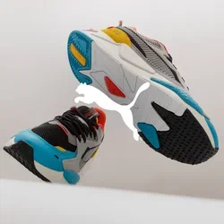 Kleurige sport sneakers met een mix van grijze, zwarte en witte materialen, aangevuld met levendige accenten in rood, oranje, geel en blauw.