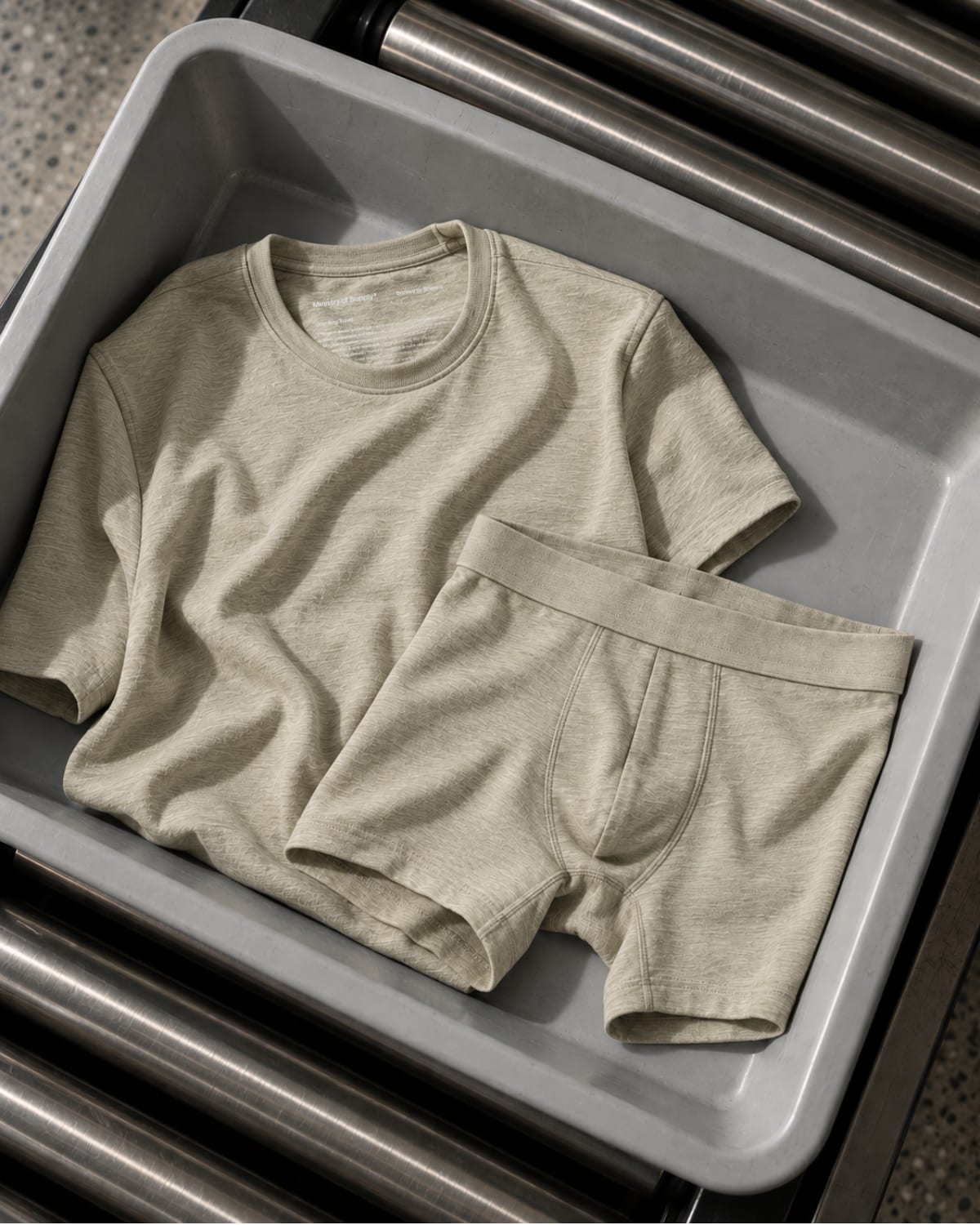 Travel Merino Tee and Boxer Brief in the new Linen colorway, folded on a stainless steel tray