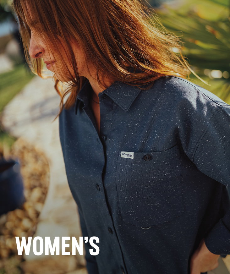 A woman wearing a dark blue button-up shirt with text: WOMEN'S