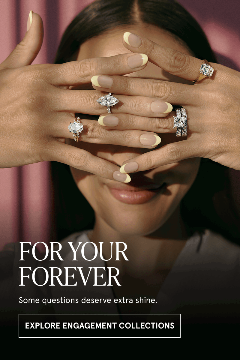 Model wearing assortment of different-shaped diamond rings & bands.  Click here to explore engagement collections