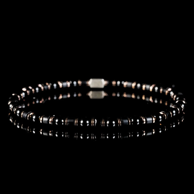 Black beads with reflective surfaces and small metal accents.