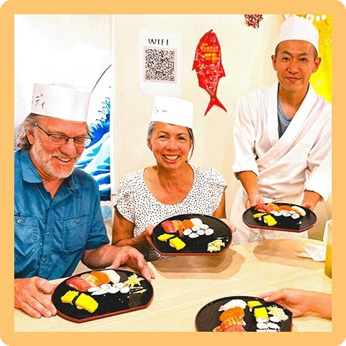 Image Description: Sushi making class with a couple and the instructor holding their plates of sushi to the camera.