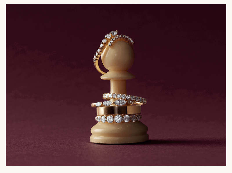 Four diamond bands & paved eternity bands curved along white ivory chess pawn.