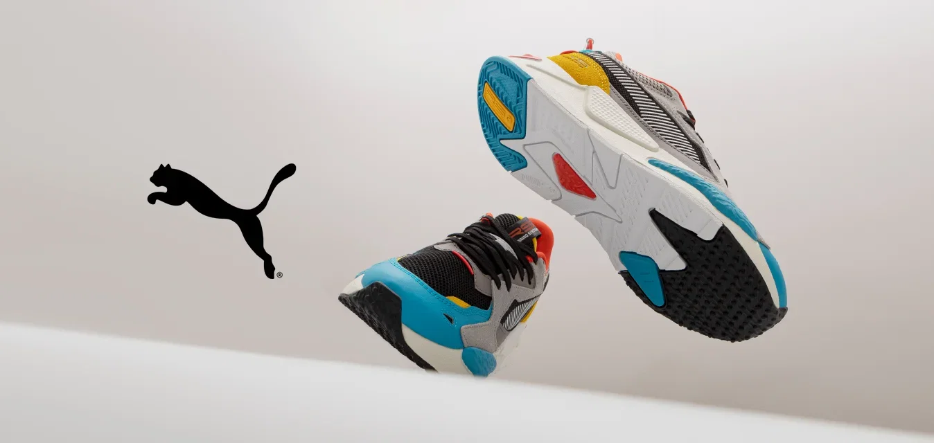 Kleurige sport sneakers met een mix van grijze, zwarte en witte materialen, aangevuld met levendige accenten in rood, oranje, geel en blauw.