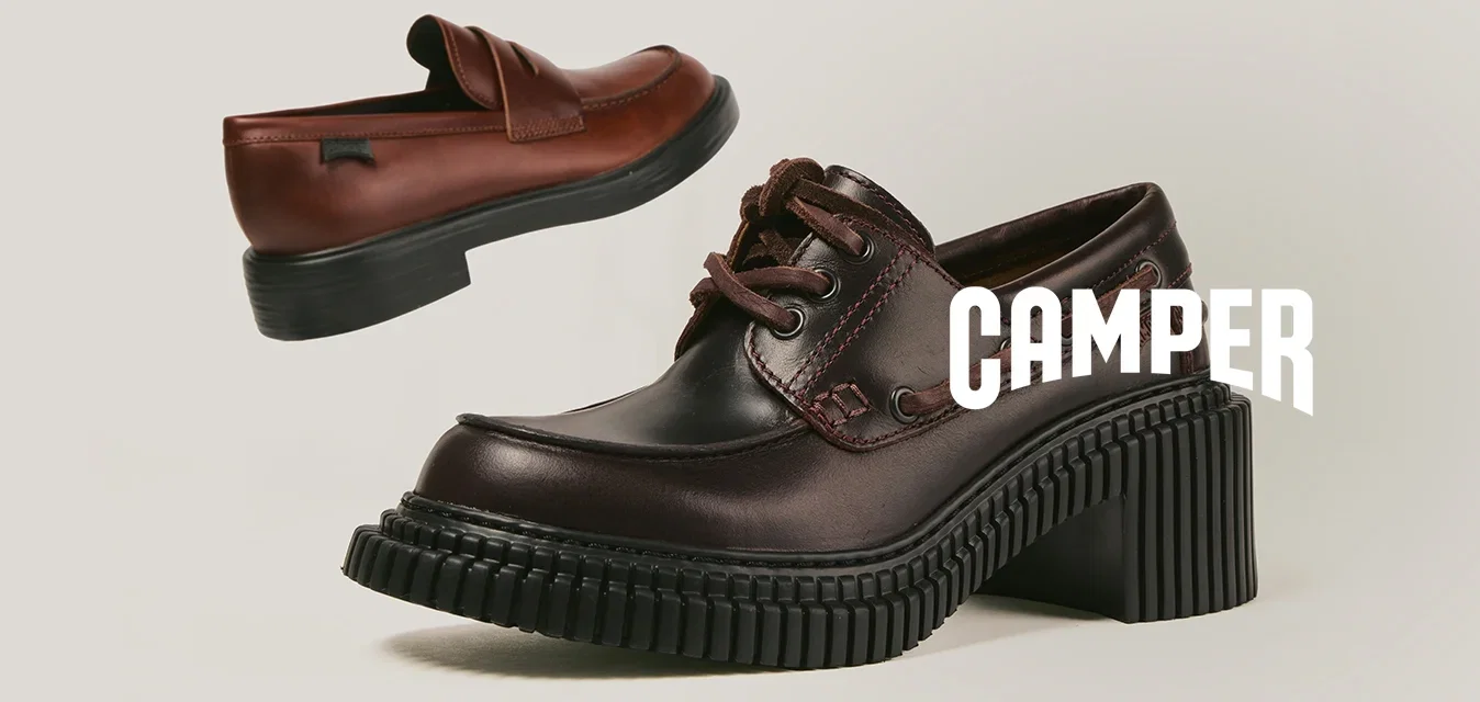 Twee bruine leren schoenen met zwarte chunky zolen, één instapschoen en één veterschoen, tentoongesteld tegen een eenvoudige beige achtergrond.