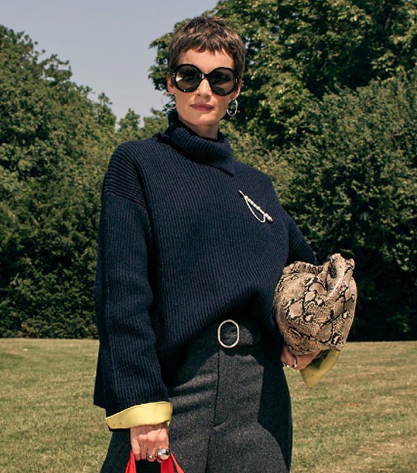 Woman wearing knitted jumper and sunglasses.
