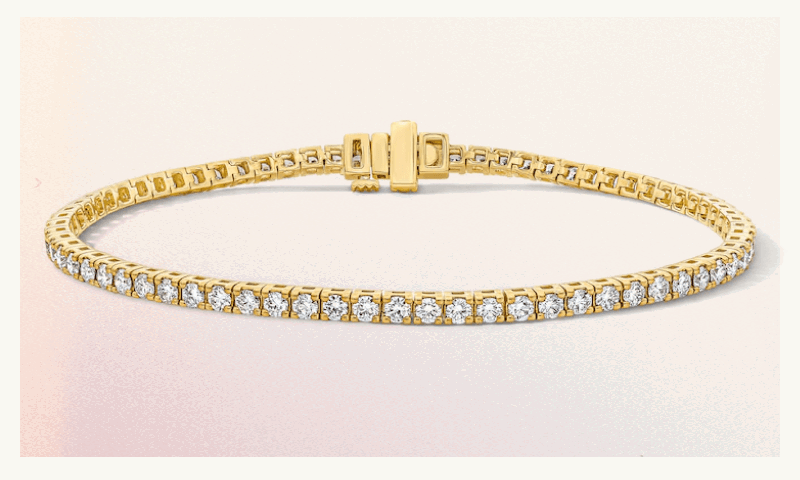Gold-set tennis bracelet, comprised of continuous round-cut diamonds. 