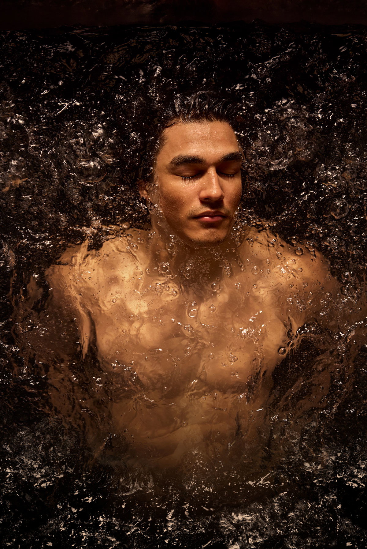 Person reclining in a warm bath with water surrounding the shoulders and neck.