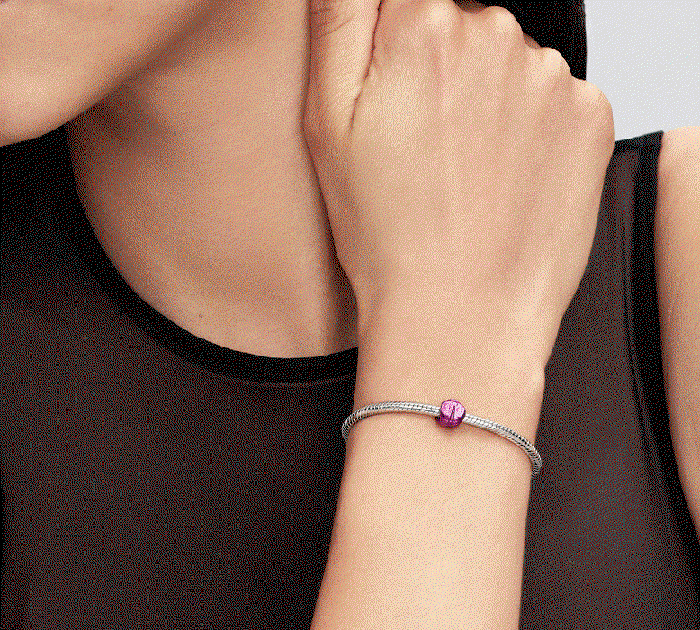 Model wears bracelet featuring a pink ladybird mini