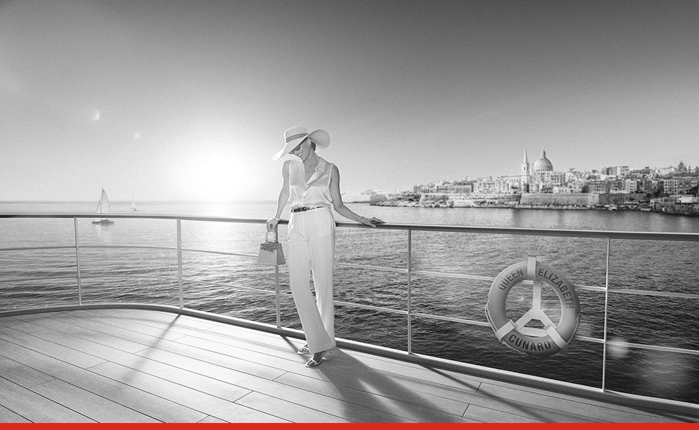 A woman standing by the rail with the Mediterranean city scape in the background