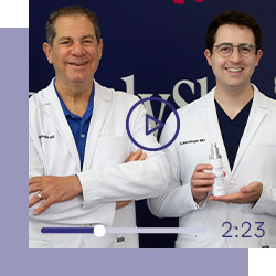 Drs. Joel and Daniel Schlessinger smiling with NEW LovelySkin LUXE Firming Peptide Neck Cream