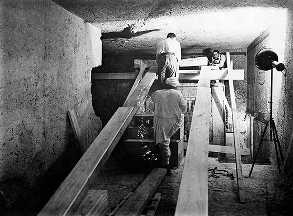 Howard Carter pictured within Tutankhamun's tomb in 1922. Carter is on the right of the image.