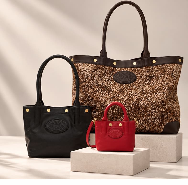 Three sizes of the Hammitt Olympia bag displayed together in black, red, and textured brown finishes with gold hardware.