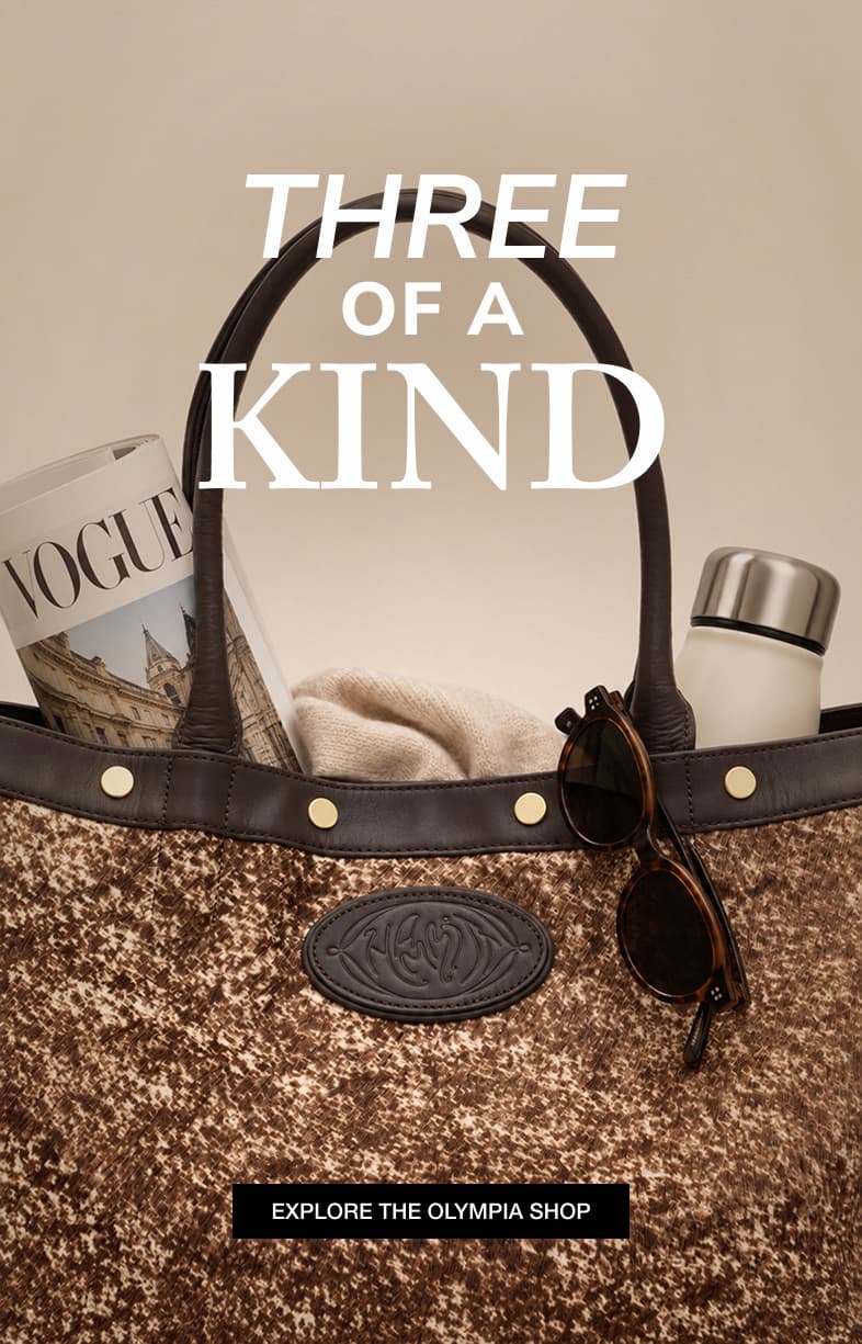 Close-up of a textured brown Hammitt Olympia tote filled with everyday essentials, including a magazine, sweater, water bottle, and sunglasses. Text reads “Three of a Kind” with a button to explore the Olympia Shop.