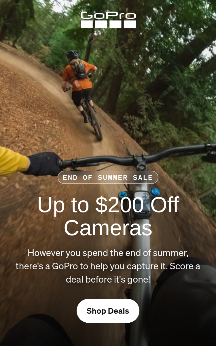 First-person view of three mountain bikers riding through a forest trail.