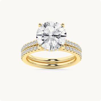 Round Lab Grown Diamond 5 5/8ctw. Classic Engagement Ring in 14k Yellow Gold: Yellow gold bridal set with a round brilliant-cut diamond in a four-prong setting on a pavé band, paired with a matching pavé wedding band.