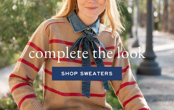 complete the look - shop sweaters - close up of girl wearing a tan and red striped sweater and sitting on a bench