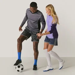Twee mensen in sportkleding spelen voetbal, waarbij de een de bal met zijn voet controleert en de ander probeert deze af te pakken.