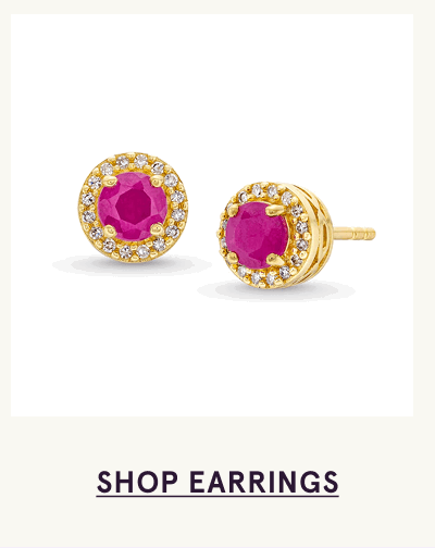 A pair of gold stud earrings featuring vibrant round pink rubies surrounded by diamond halos. Click here to shop earrings