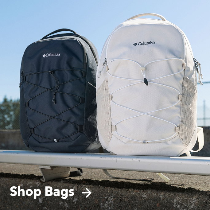 A black and white backpack sitting on bleachers with text: Shop Bags